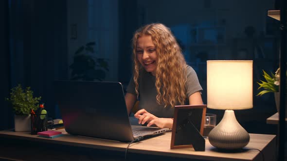 Young Pretty Girl Celebrates the Triumph of Working at Home at Night
