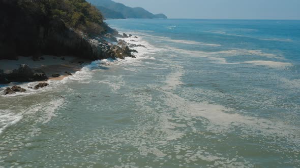 Aerial view of flock of pelican birds flying along pacific coastline