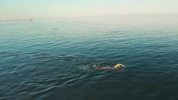 Aerial View of Young Woman Swimming in the Transparent Turquoise Sea Water alt
