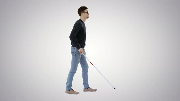 Blind Young Man with a Cane Walking on Gradient Background. alt