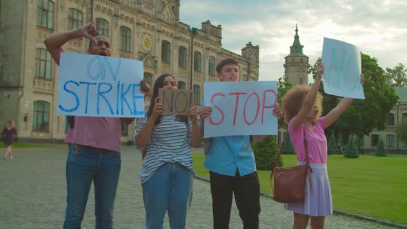 Young People Protesting Holding Placards with Inscriptions Outdoors alt