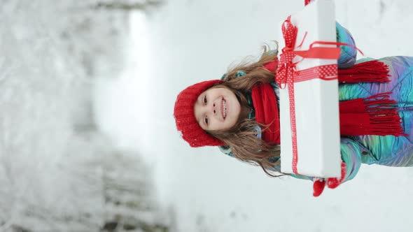 Vertical Video of Surprised Cute Girl 6-7 Years Holding in Hands Birthday Presen in Festive Package