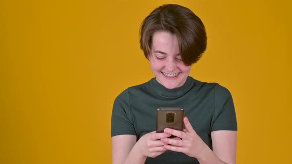 happy lucky girl using phone looks and sees the message with a good news.