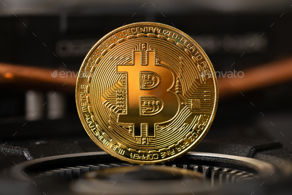 Gold bitcoin standing on crypto mining GPU computer hardware