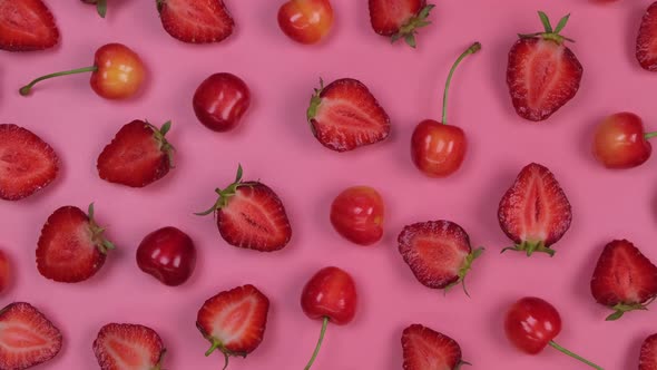 Rotating Background of Ripe Strawberries and Cherries on a Pink Background