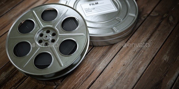 Vintage film reel with filmstrip on wood background. Video, cine