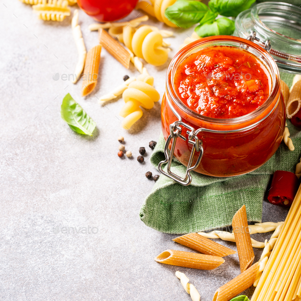 Glass jar with homemade classic spicy tomato pasta or pizza sauce.