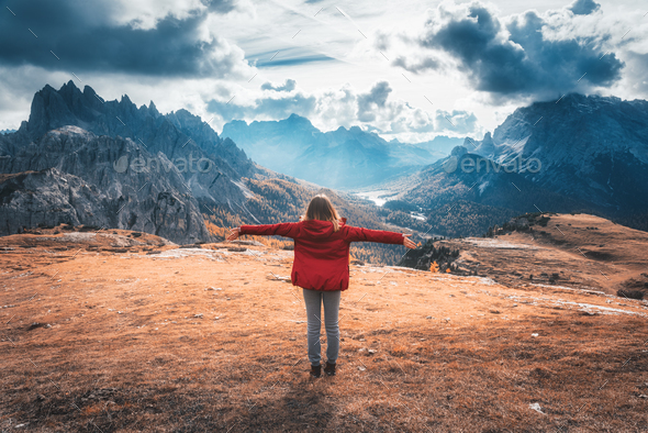 Young woman with raised up arms and mountains at sunset - Stock Photo - Images