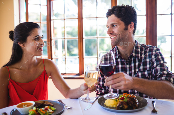 Smiling couple toasting wine glass at the table in restaurant Smiling couple toasting wine glass at the table in restaurant
