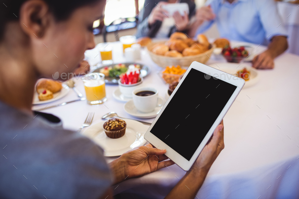 Close-up of businesswoman using digital tablet in restaurant Close-up of businesswoman using digital tablet in restaurant
