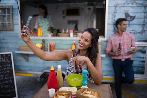 Beautiful woman taking selfie from mobile phone in cafeteria Beautiful woman taking selfie from mobile phone in cafeteria