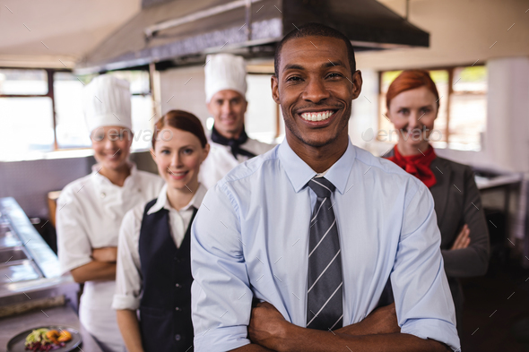 Group of hotel staffs standing with arms crossed in kitchen at hotel Group of hotel staffs standing with arms crossed in kitchen at hotel