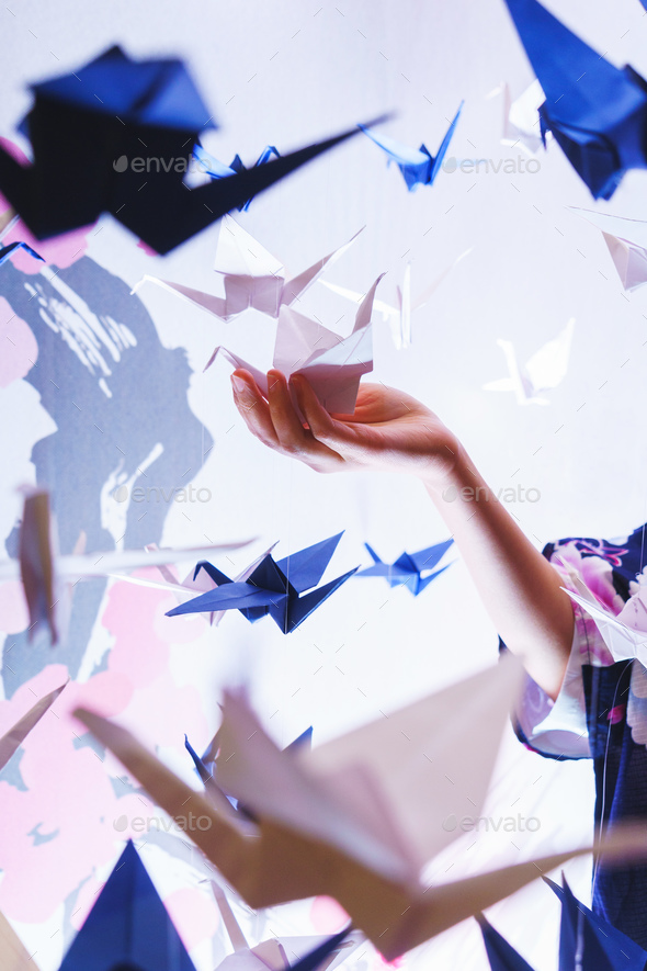 Girl holding a traditional Japanese origami swan made out of pap - Stock Photo - Images