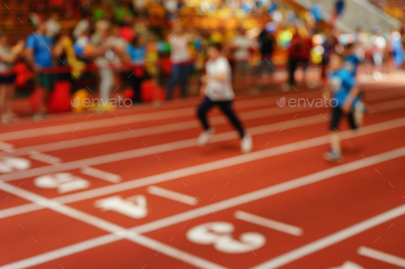 Blurred image of children athletes on a racetrack during finishi - Stock Photo - Images