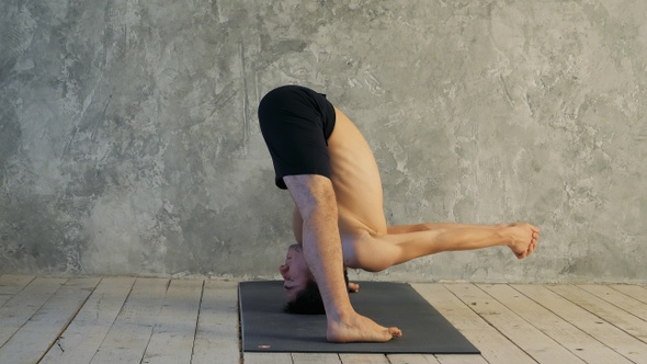 Sporty muscular young yogi man doing Wide-Legged Forward alt