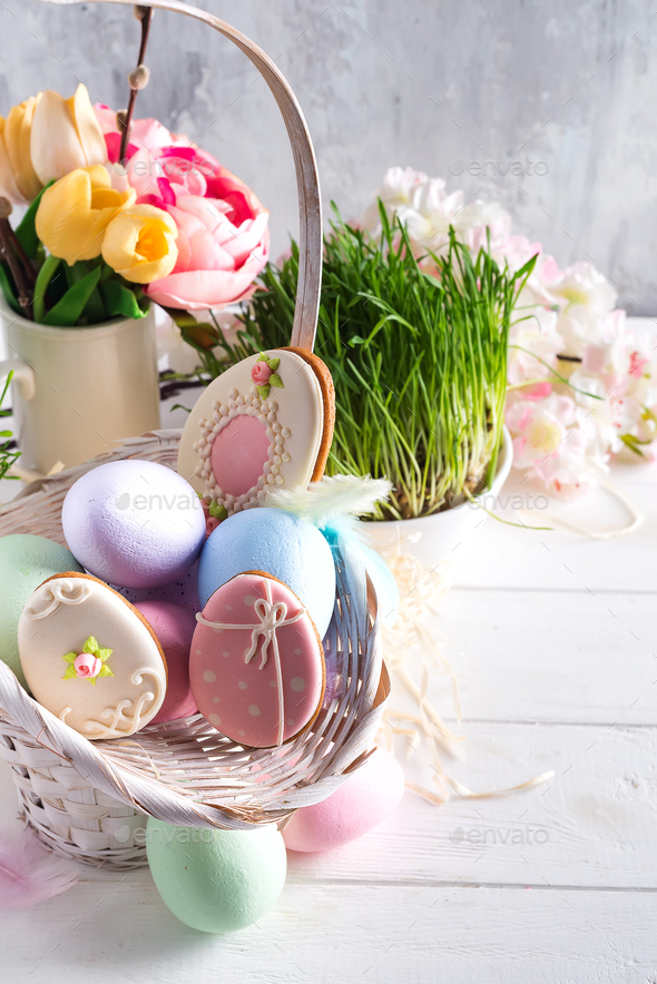 Easter greeting card with glazed cookies and colorful easter eggs in basket . With copy space - Stock Photo - Images