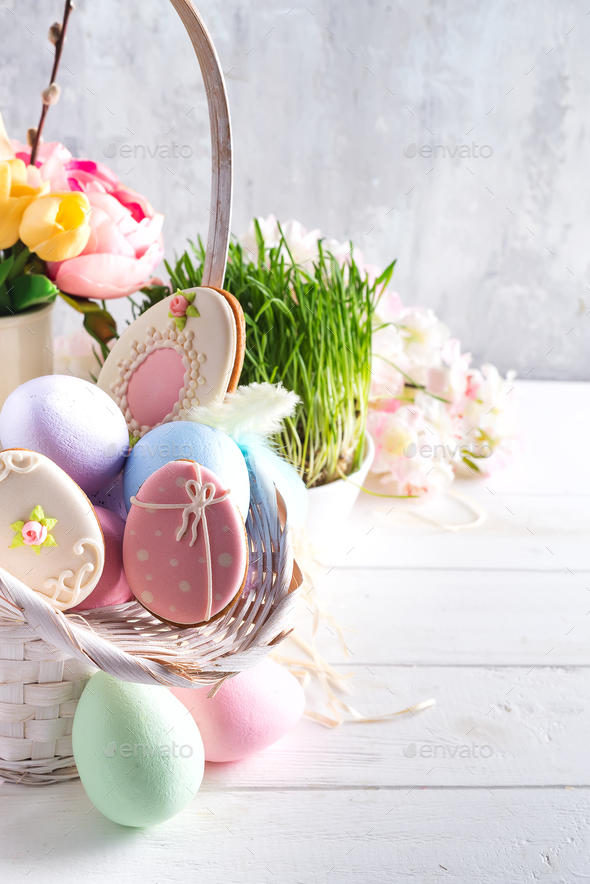 Easter greeting card with glazed cookies and colorful easter eggs in basket . With copy space - Stock Photo - Images