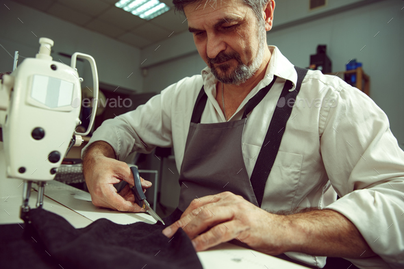 Sewing process of the leather belt. Old Man's hands behind sewing. - Stock Photo - Images
