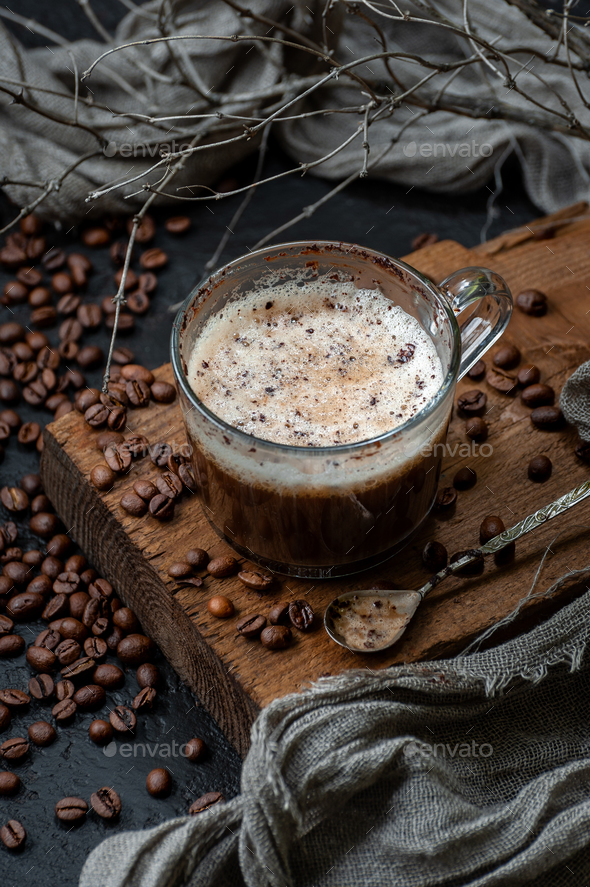 Coffee with milk foam on a wooden board and a scattering of coff - Stock Photo - Images