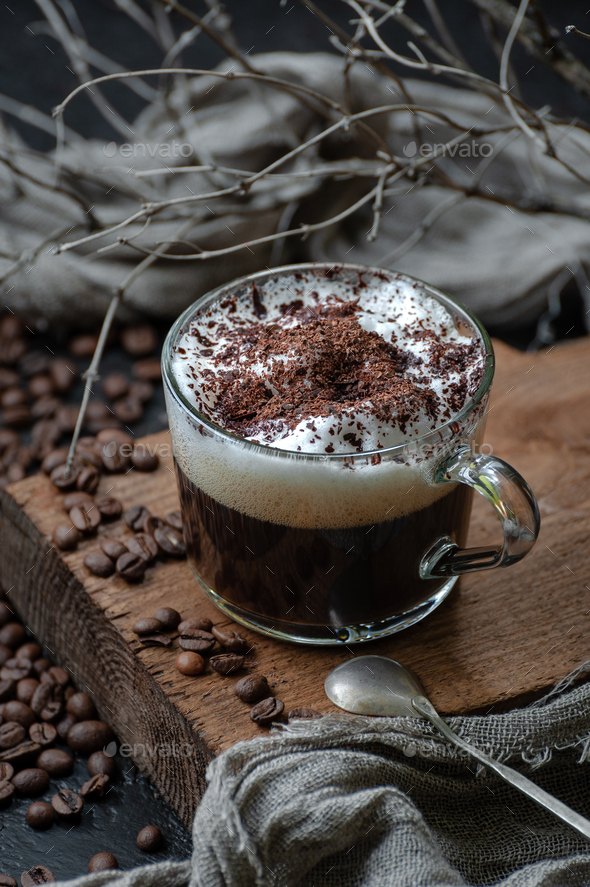 Coffee americano with milk foam and chocolate on a wooden board - Stock Photo - Images