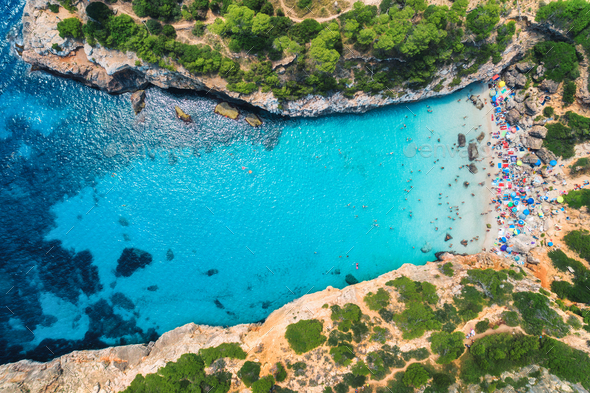 Aerial view of sandy beach with colorful umbrellas and trees - Stock Photo - Images