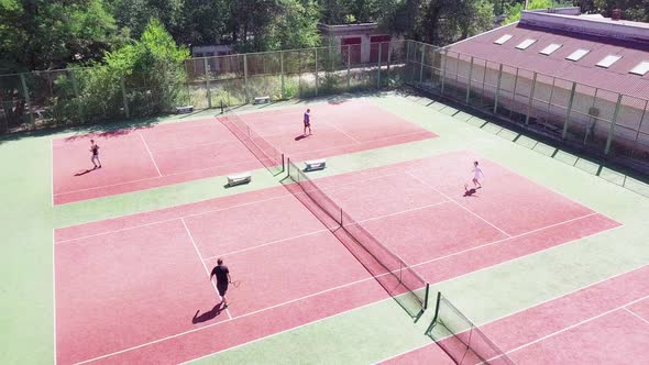 People Playing Tennis on Court in Summer