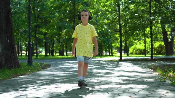 Caucasian boy walks in the park, looking surprised and thoughtful on a sunny summer day  alt