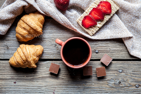 delicious breakfast with a cup of coffee and fruit sandwiches, croissants. Strawberries, food