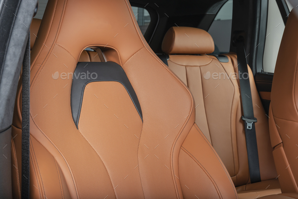 Red perforated leather car seat with the unfocused car interior in the  background Stock Photo by gargantiopa