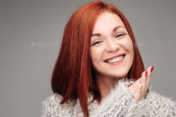 Charming woman with ginger hair smiling and putting hands together - Stock Photo - Images