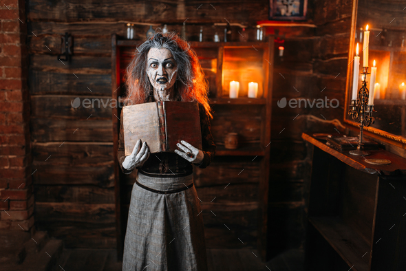 Witch holds spellbook, dark powers of witchcraft - Stock Photo - Images