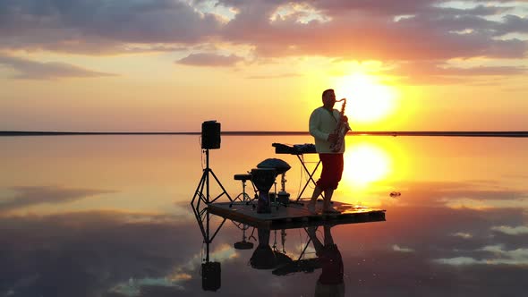Colorful Sunset in the Background of a Saxophonist Playing in the Sea,  alt