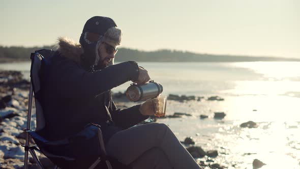 Man Warming Hands Steaming Cup Of Mate Tea. Male Hands With Mug Of Hot Drink Cold Winter Outdoors. alt