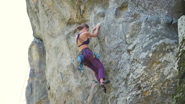 Strong Female Climber Climbing Steep Wall of Rocky Mountain alt