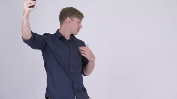 Happy Young Handsome Businessman Video Calling with Phone alt