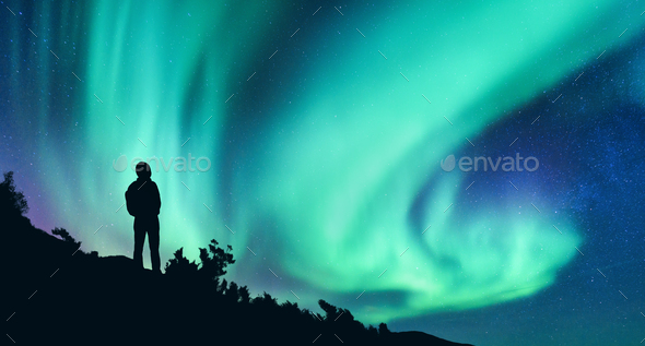 Aurora borealis and silhouette of a woman with backpack at night - Stock Photo - Images