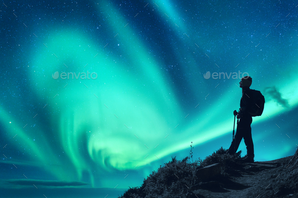 Aurora borealis and silhouette of a woman with backpack at night - Stock Photo - Images