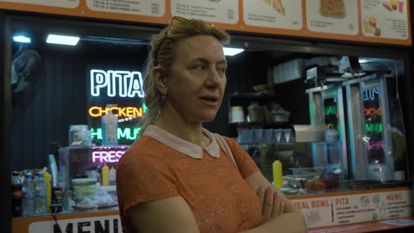 Woman in Stylish Glasses Looking Thoughtfully at the Camera Smiling Slightly alt