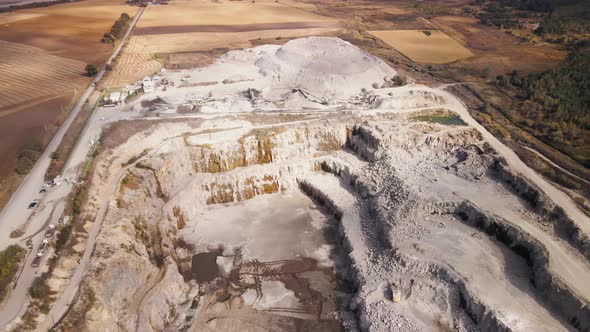Aerial View of Slope Operating Granite Quarry with Mining Equipment on Ledges alt