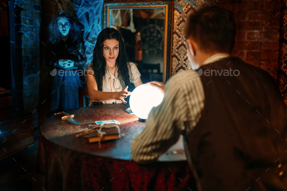 Couple on spiritual seance, witch on background - Stock Photo - Images
