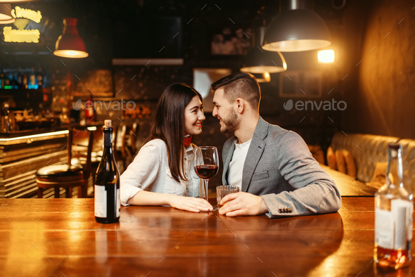 Romantic evening in bar, couple kissing at counter Stock Photo by NomadSoul1