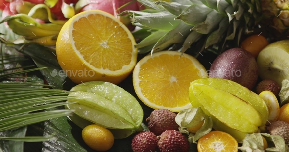 Panoramic video healthy fresh tropical fruits background with pouring water. Motion, 4K UHD video
