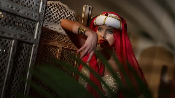 a Woman in a Turban a Red Scarf and a Sequined Dress Dances in the Sunset Light alt