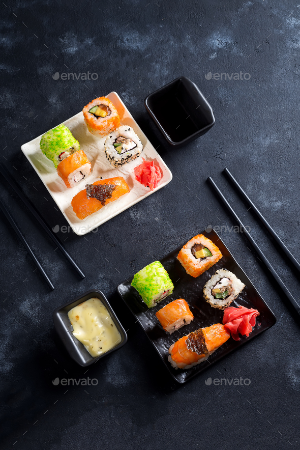 Traditional Japanese food- sushi, rolls, chopsticks, soy sauce on black slate background. Sushi menu