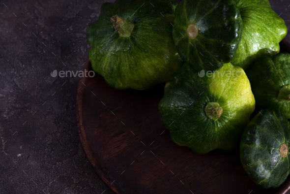 small size patty pan patisson squash on plate on dark wooden background with copy space