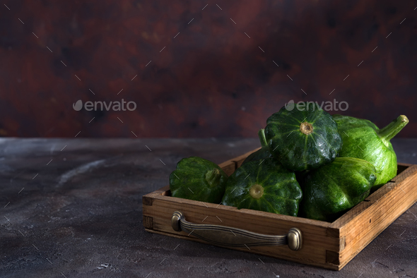 small size patty pan patisson squash in wooden box on dark wooden background with copy space
