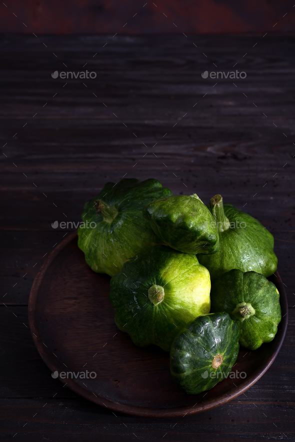 small size patty pan patisson squash on plate on dark wooden background with copy space