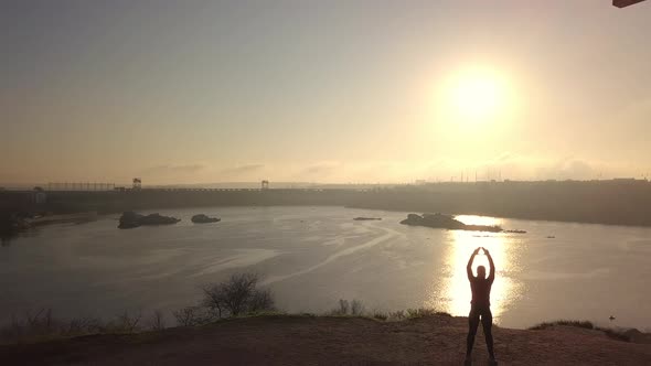 Woman Practicing Martial Arts at Riverside at Sunset