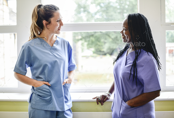 Nurses having a conversation in the hospital hallway - Stock Photo - Images