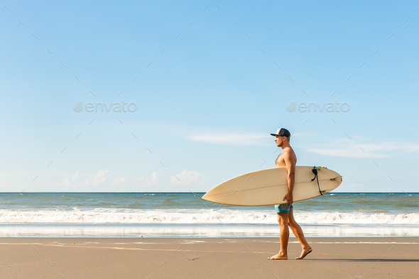 Handsome man with surfing board on spot. - Stock Photo - Images